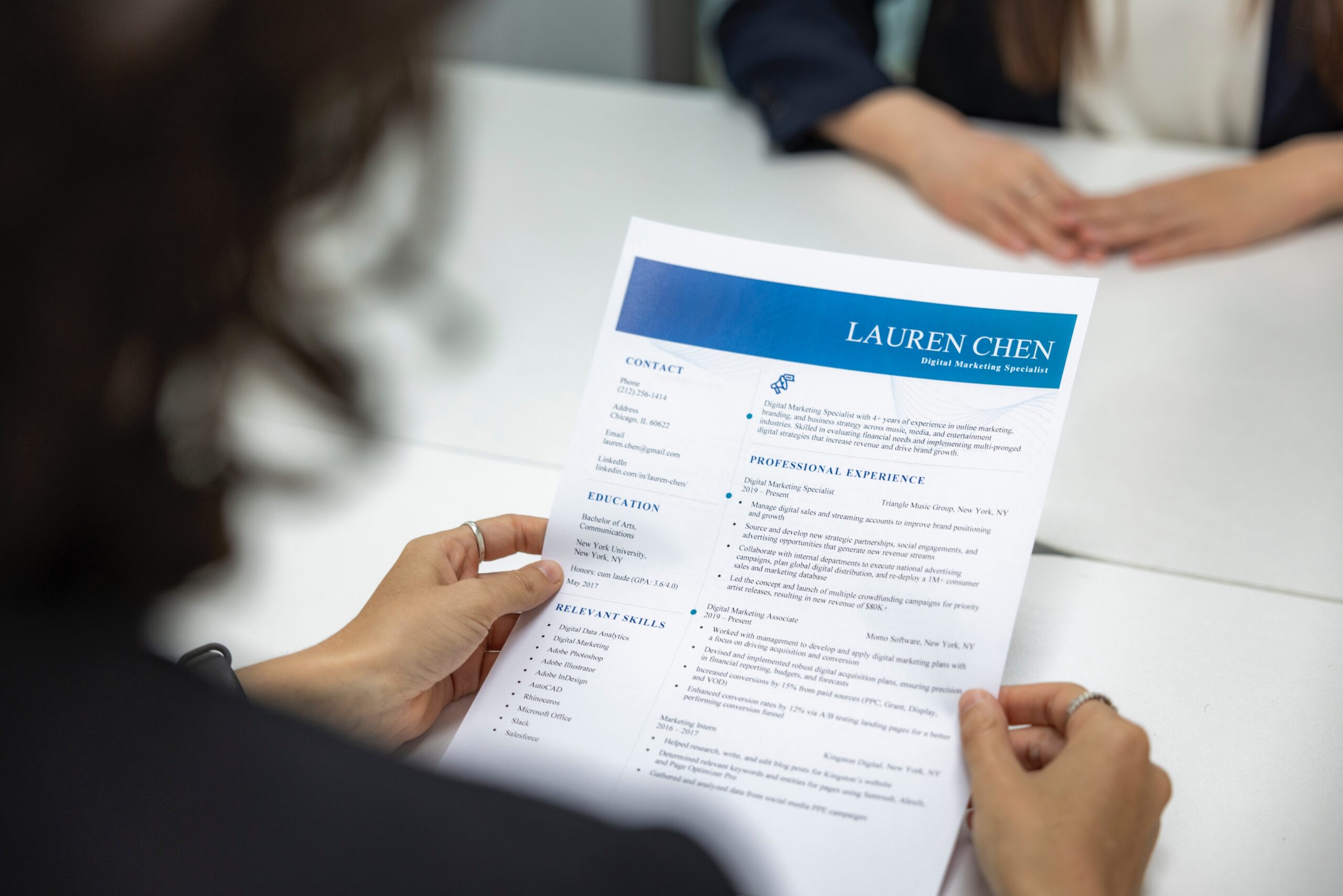 A photo of a hiring manager reviewing an applicant's resume.